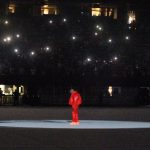 Kanye West, seul en doudoune et pantalon rouges au milieu du Mercedes-Benz Stadium à Atlanta pour la première listening party de Donda.